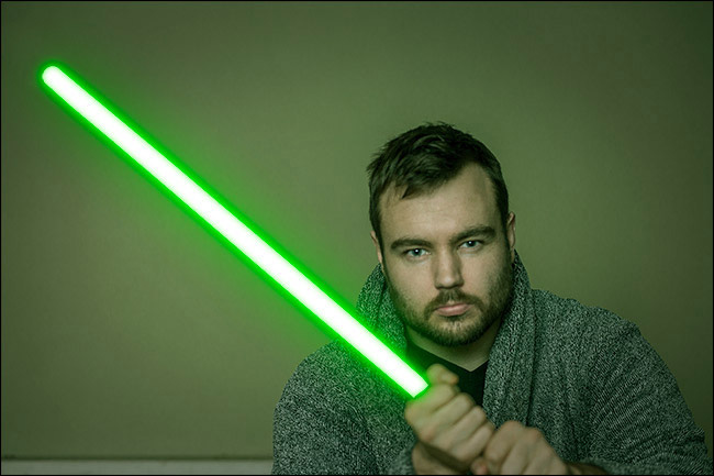 A composite photo of the author holding a lightsaber