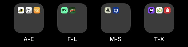 Four folders on an iOS Home screen labeled alphabetically.