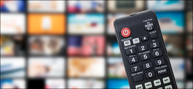 A TV remote with a backdrop of streaming services and TV channels.