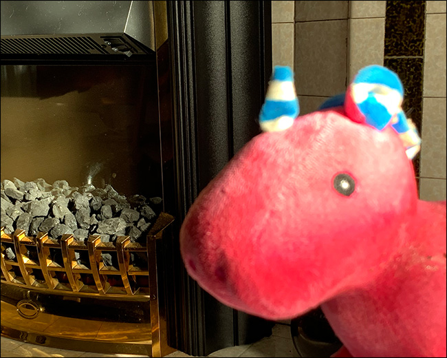 A close-up of a blurry stuffed unicorn with the fireplace behind it in focus, instead.